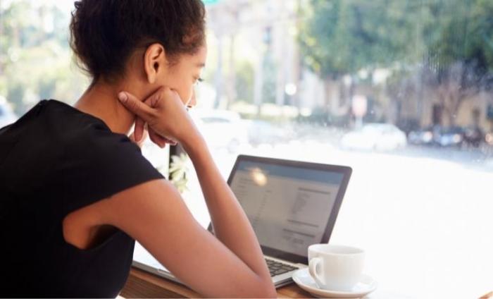 Businesswoman Using Laptop In Coffee Shop